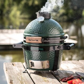 Mini Big green egg sitting on a wooden table.